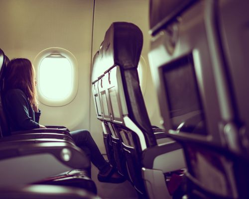 vue-laterale-d-une-femme-voyageant-dans-un-avion-assise-pres-de-la-fenetre-min